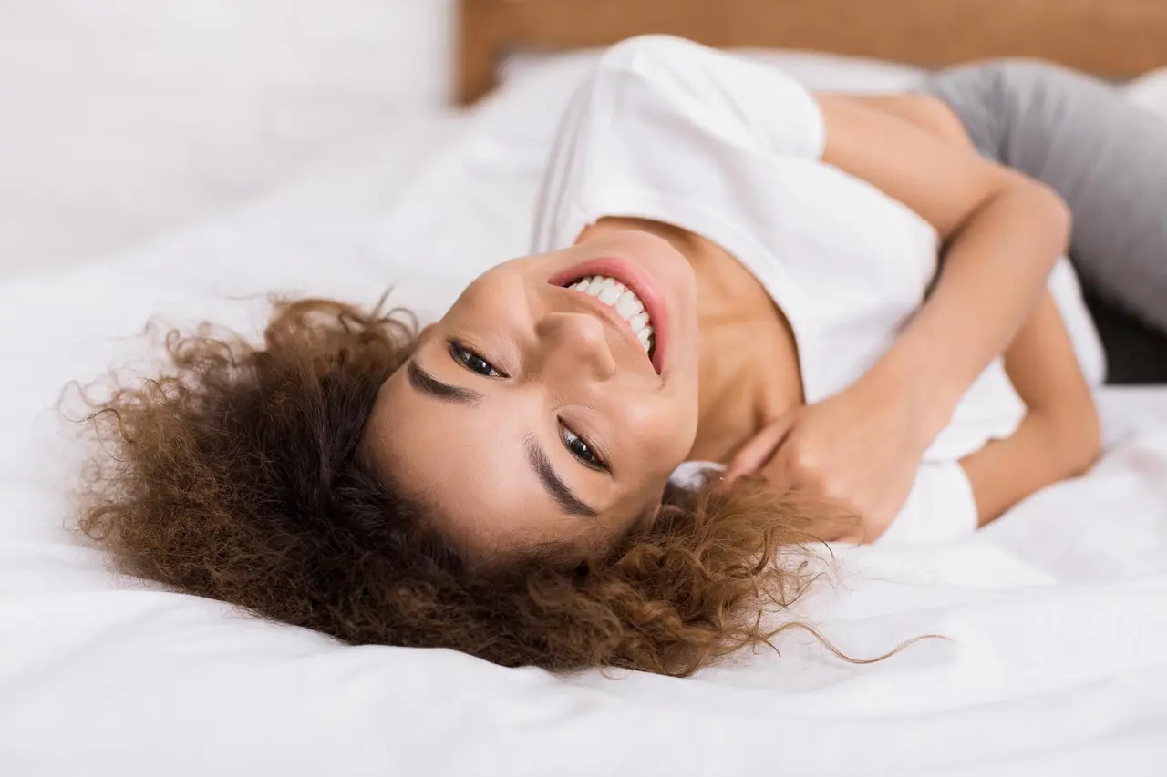Well-rested woman waking up refreshed after treating sleep apnea