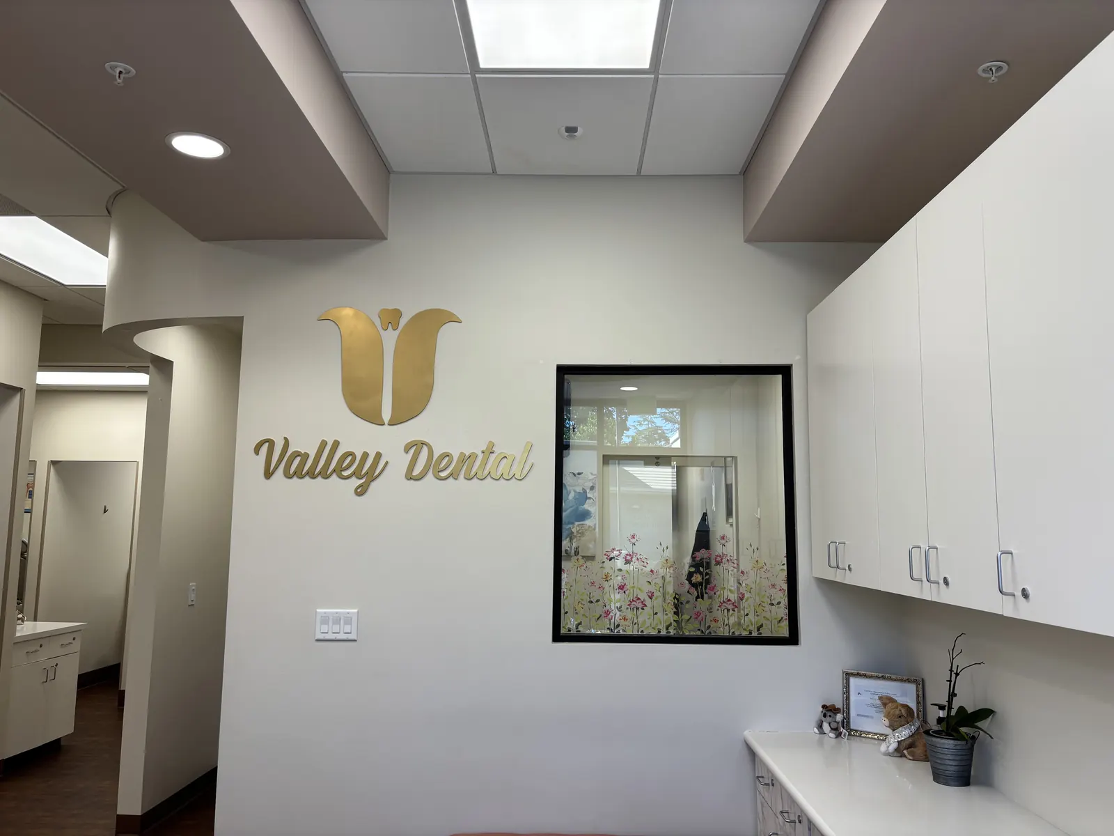 The gold Valley Dental logo on the wall inside our Turlock office