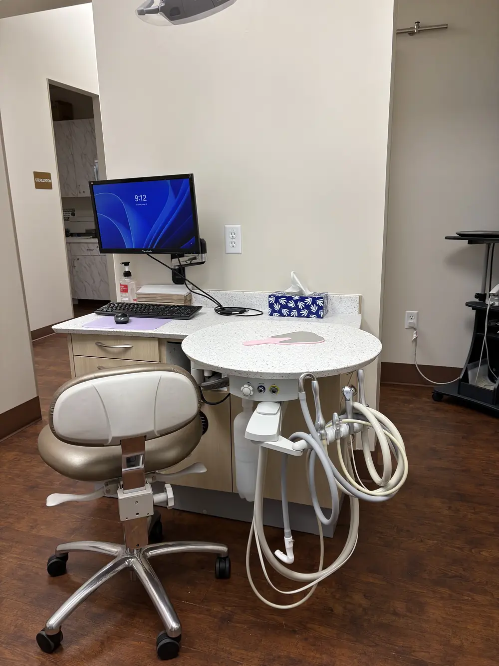 A chairside workstation with a monitor and dental delivery unit at Valley Dental Turlock